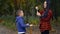 Adult brunette mother blows a bubble with her son at the park