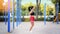 Adult brunette sports woman jumping with a rope on a street gym at warm summer day