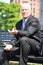 Adult Businessman And Confusion Wearing Suit Sitting On Bench