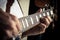 Adult caucasian guitarist portrait playing electric guitar on grunge background. Close up instrument detail. Music