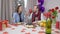 Adult Caucasian man feeding woman with sweet tasty candy sitting at Valentine's dinner table indoors. Smiling loving