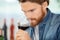 Adult caucasian man smelling glass red wine