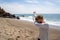 Adult caucasion woman does a dabbing dance move while on the beach. Taken at Point Dume Malibu California