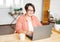 Adult charming brunette woman in glasses plus size body positive working with laptop at home