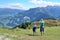 Adult and child looking to paraglider flying over beautiful mountains and valley.