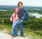 Adult and child standing on a mountaintop near river.