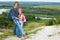 Adult and child standing on a mountaintop near river.