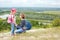 Adult and child standing on a mountaintop near river.