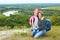 Adult and child standing on a mountaintop near river.