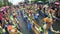 Adult children in ornate coconut costume parades along the street, a festival to honor a patron saint