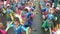 Adult children in ornate coconut costume parades along the street, a festival to honor a patron saint