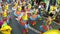 Adult children in ornate coconut costume parades along the street, a festival to honor a patron saint