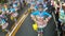 Adult children in ornate coconut gown costume parades along the street, a festival to honor a patron saint