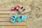 Adult and childrens` shoes on wooden boardwalk with sand at beach