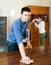 Adult couple dusting wooden furniture