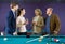 Adult couples of different generations talk in the billiard room