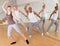 Adult dancers practicing synchronous choreography in studio