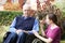 Adult Daughter Comforting Senior Father In Wheelchair