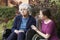 Adult Daughter Comforting Senior Mother In Wheelchair