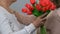 Adult daughter giving flowers to senior mom, respect for older generation