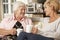 Adult Daughter Visiting Senior Mother Sitting On Sofa At Home