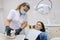 Adult female dentist treating patient woman teeth. Medicine, dentistry and healthcare concept