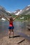 Adult female hiker with back facing the camera, and arms raised in Lundy Canyon near Mammoth Lakes in the Eastern Sierra Nevada