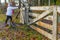 Adult female hiker leaving Dutch nature reserve Geleenbeekdal, opening gate