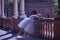 Adult female Hispanic classical ballet dancer making figures leaning on a stone balustrade, wearing a white tutu