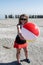 An adult female holds a beach ball in the air at the abandoned Bombay Beach at the Salton Sea in Southern California