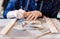 Adult female potter master cutting the clay on table.