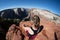 Adult female sits with back facing camera looking over Observation Point in Zion National Park in Utah, an 8 mile hike to the