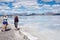 Adult female tourist takes photos of another tourist at the Bonneville Salt Flats