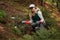 Adult female volunteer cleans garbage and plastic that pollutes environment in forest