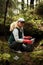 Adult female volunteer cleans garbage and plastic that pollutes environment in forest