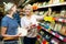 Adult girl with senior mother in cheese section of supermarket