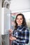 Adult girl in shirt near boiler control panel