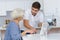 Adult grandson teaching grandma using computer