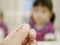 Adult hand catching a mosquito on a defocus background of little baby girl