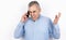 Adult handsome man with grey hair wearing blue shirt having phone conversation looks angry standing on  white background,