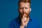 Adult handsome redhead bearded frowning man doing silence gesture