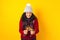 Adult hispanic woman holding christmas sparkling lights for mexican posada in christmas on yelllow background in Mexico Latin Amer