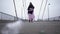 Adult homeless woman stay on the bridge near the river port in cold windy grey weather asking for help and begging money