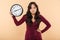 Adult lady with curly long hair holding clock with time after 8