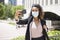 Adult latina woman taking a picture with mobile phone. She dresses formal with face mask