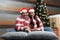 Adult Latino man and woman couple have Christmas presents lying on the bed by the tree with spheres give each other hugs and kisse