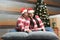 Adult Latino man and woman couple have Christmas presents lying on the bed by the tree with spheres give each other hugs and kisse