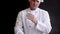 Adult male chef in a suit knocks his hands from the flour. Slow motion with flour particles