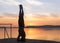 Adult male doing yoga exercises at sunset, head stand