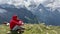 Adult male in red hoodie with hood enjoying beautiful view in mountainous area.